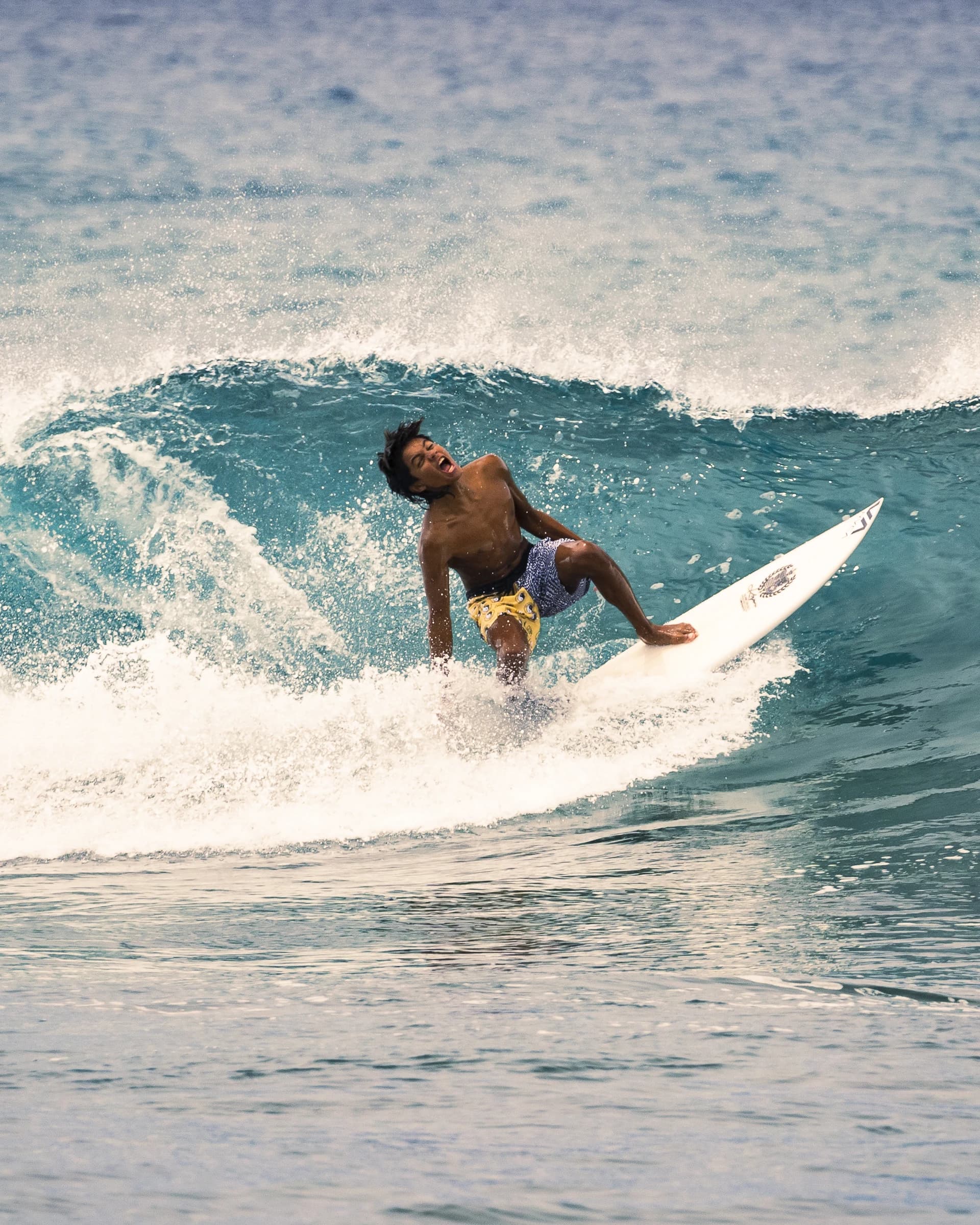 Surfer moving along a blue wave