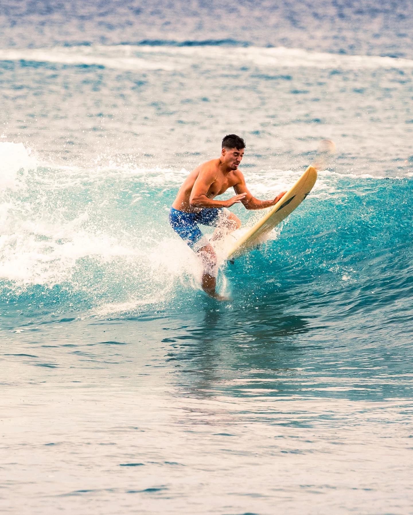 Surfer standing in a bright blue wave